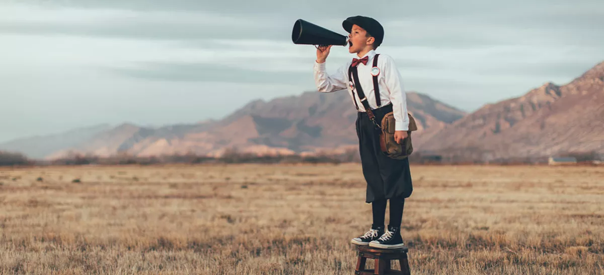 Gutt som annonserer i en ropert